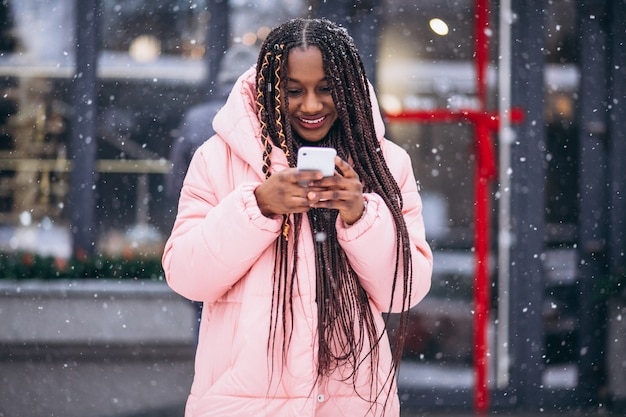 Donna afroamericana che per mezzo del telefono