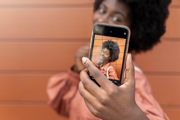 Donna afroamericana che si fa un selfie con il suo smartphone