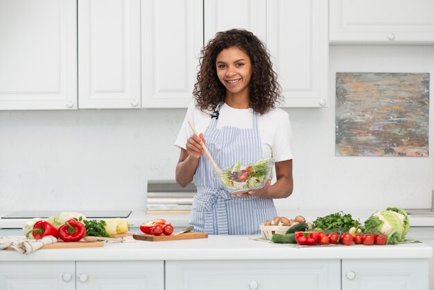 Donna afroamericana di vista frontale che prepara insalata