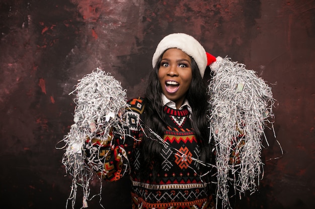 Donna afroamericana su una festa di Natale con i coriandoli