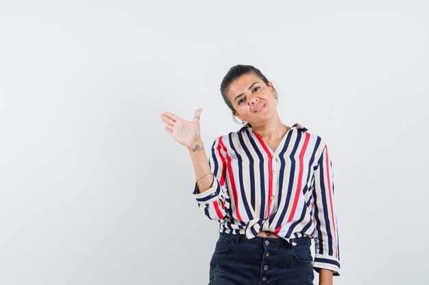 donna agitando la mano per il saluto in camicia, gonna e aspetto allegro