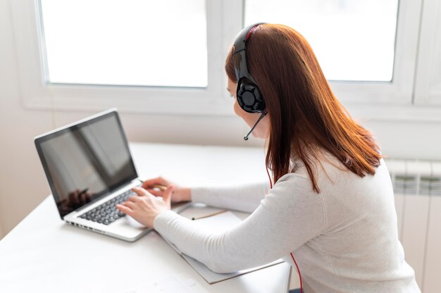 Donna al lavoro che ha videochiamata sul computer portatile