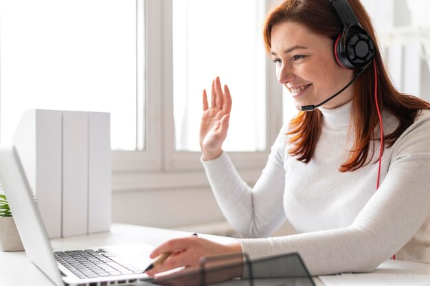 Donna al lavoro che ha videochiamata sul computer portatile