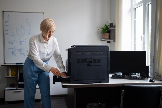 Donna al lavoro in ufficio utilizzando la stampante