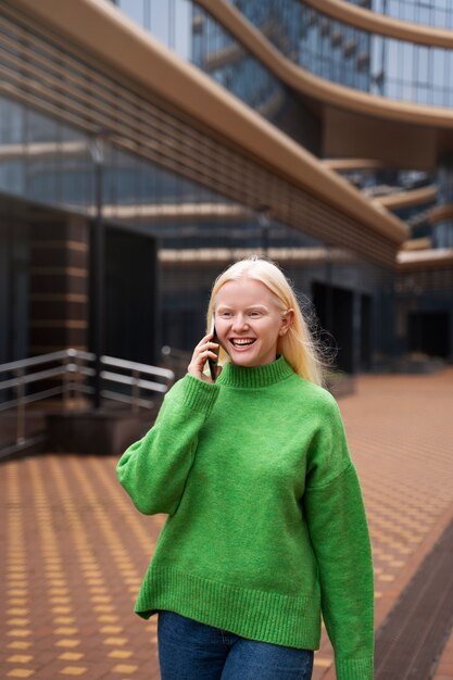 Donna albina del colpo medio che parla sul telefono