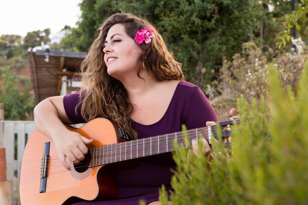 Donna all'aperto suonare la chitarra