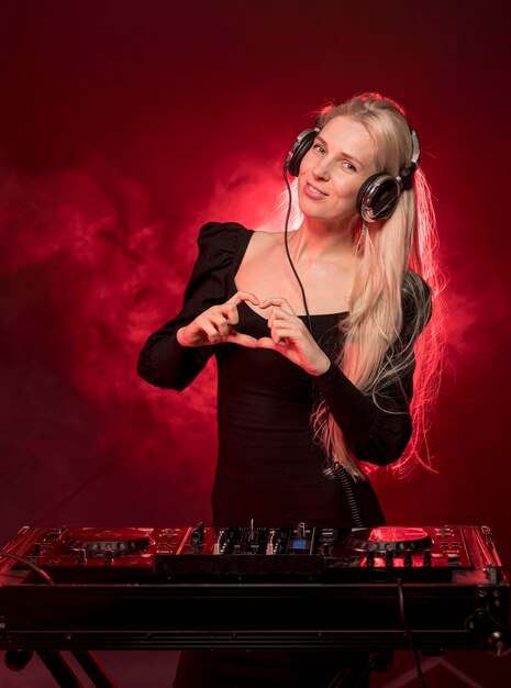 Donna alla console del DJ che mostra a forma di cuore