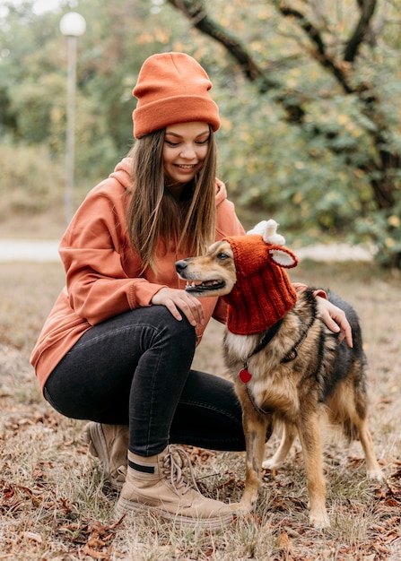 Donna alla moda a fare una passeggiata con il suo cane