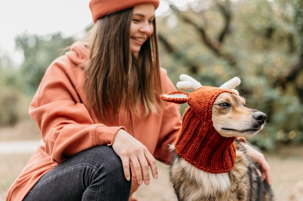 Donna alla moda a fare una passeggiata con il suo cane