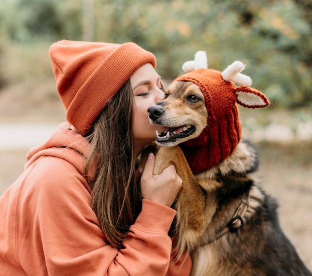 Donna alla moda a fare una passeggiata con il suo cane