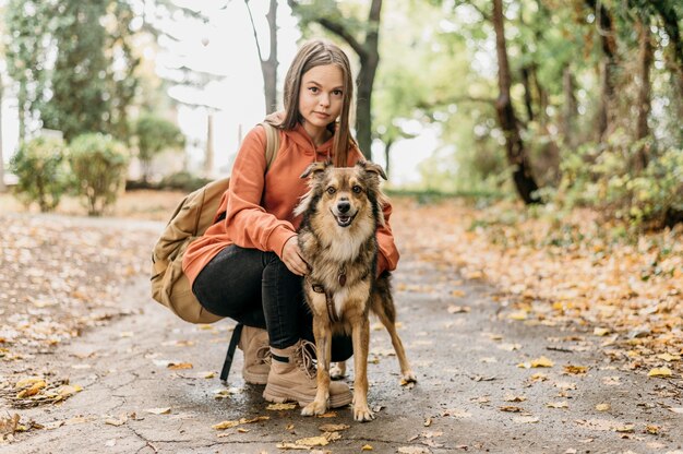 Donna alla moda a fare una passeggiata con il suo cane