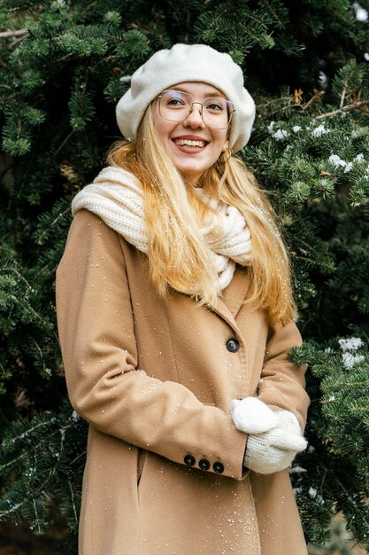 Donna alla moda che propone al parco in inverno