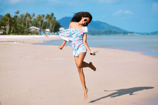 Donna alla moda divertendosi sulla bellissima spiaggia tropicale