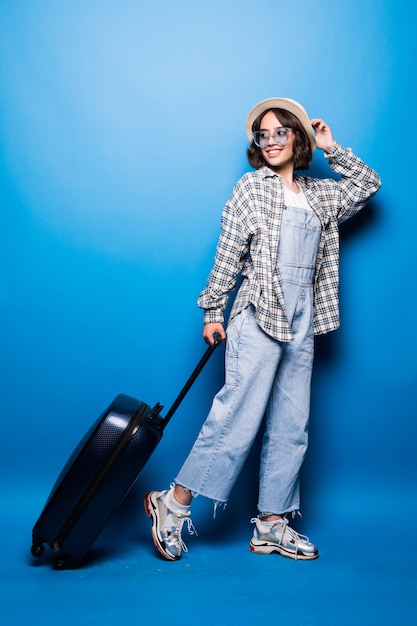 Donna alla moda in esecuzione con la valigia