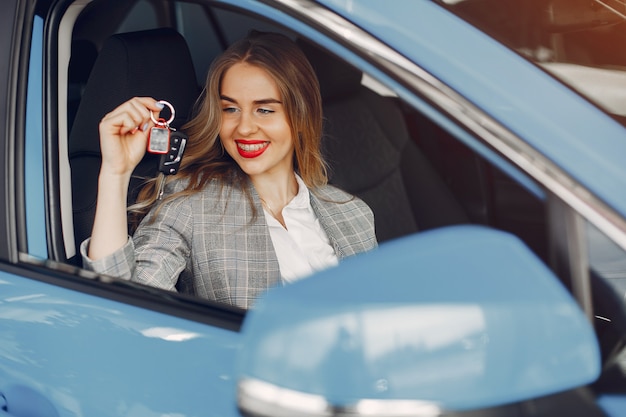 Donna alla moda in un salone di auto