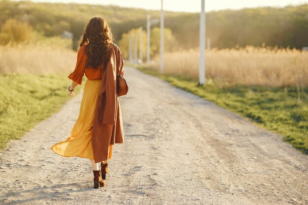 Donna alla moda trascorrere del tempo in un campo estivo