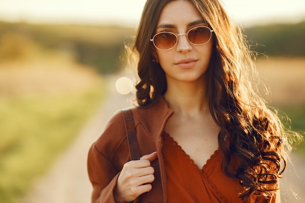 Donna alla moda trascorrere del tempo in un campo estivo