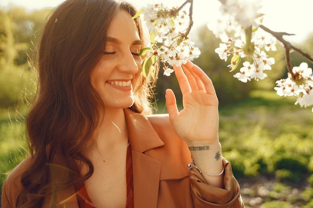 Donna alla moda trascorrere del tempo in un parco di primavera