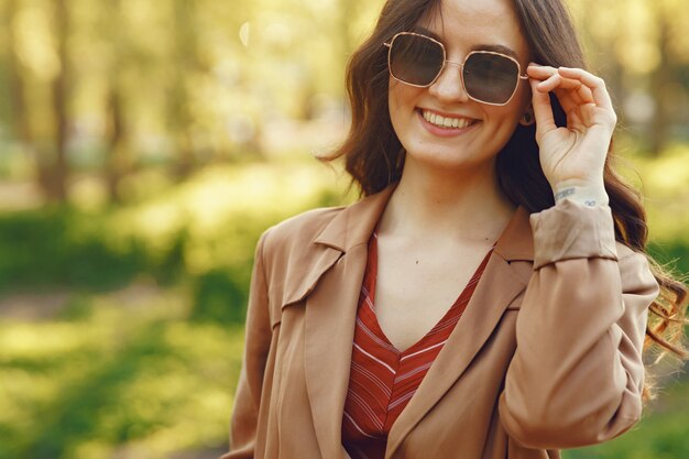 Donna alla moda trascorrere del tempo in un parco di primavera