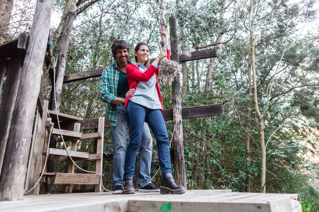 Donna allegra che tiene una corda nel parco avventura