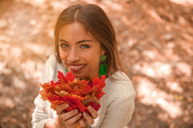 Donna allegra con foglie d&#39;autunno