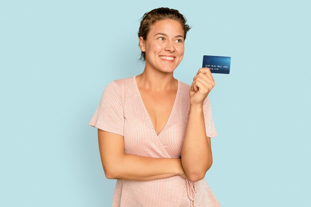 Donna allegra dello shopping che tiene il pagamento senza contanti con carta di credito