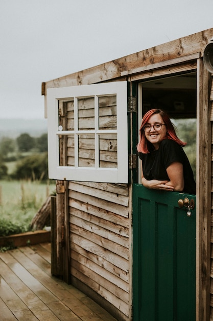 Donna allegra in una casa di legno