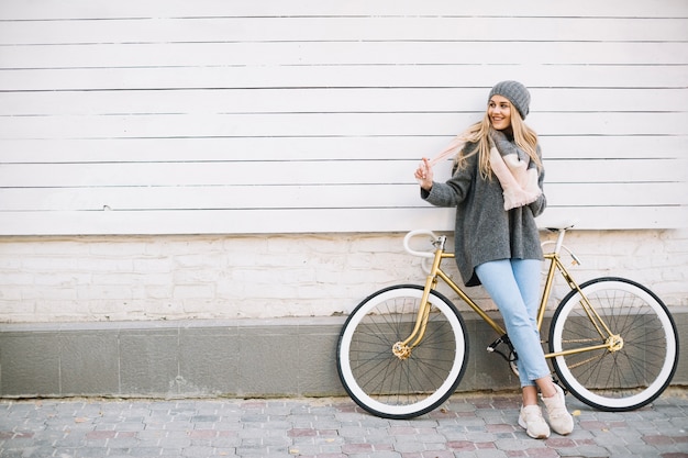 Donna allegra vicino alla bicicletta