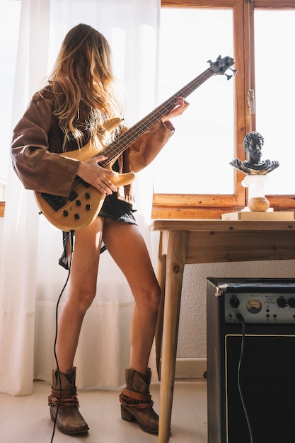 Donna anonima che gioca chitarra vicino al tavolo