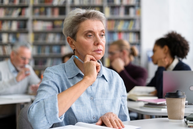 Donna anziana a tiro medio in biblioteca