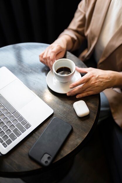 Donna anziana che beve caffè in un bar