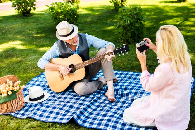 Donna anziana che cattura una foto al picnic