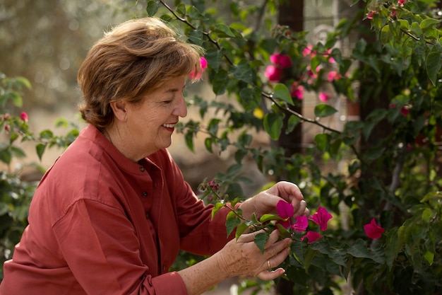 Donna anziana che si gode la natura nel suo giardino di campagna