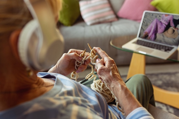 Donna anziana che studia a casa ricevendo corsi online