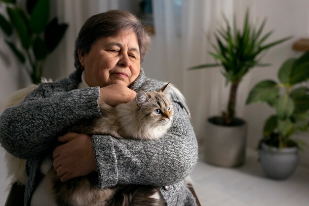 Donna anziana del colpo medio con il gatto