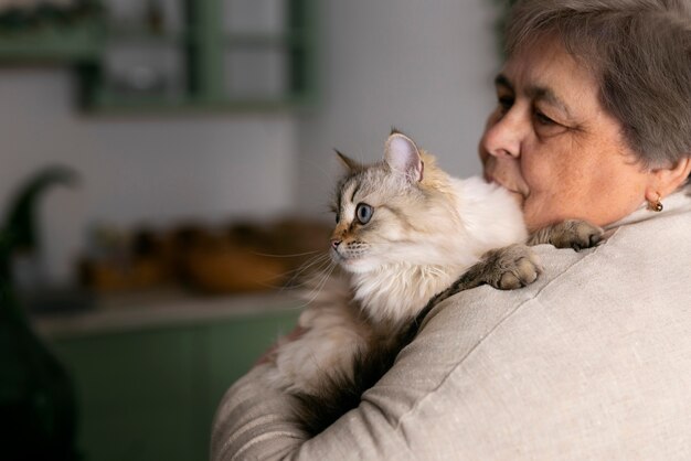 Donna anziana del colpo medio con il gatto