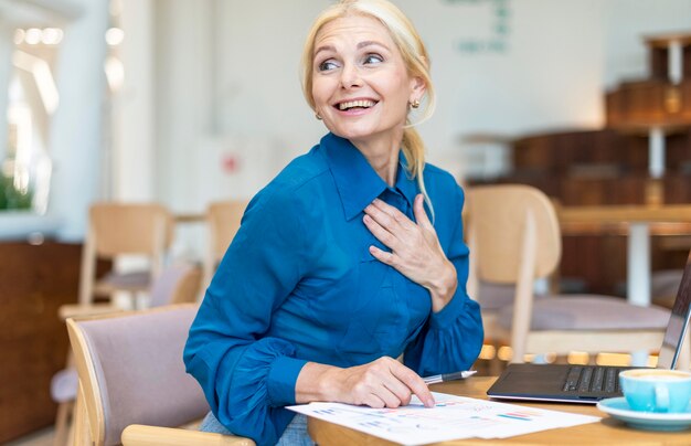 Donna anziana di affari di smiley fuori che lavora al computer portatile