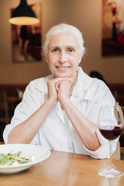 Donna anziana di vista frontale che posa al ristorante