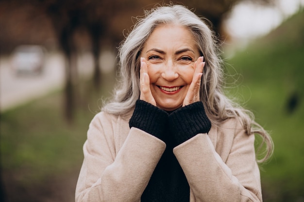 Donna anziana felice che cammina nel parco