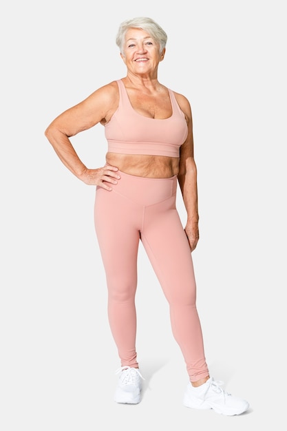 Donna anziana in buona salute in reggiseno sportivo rosa e leggings in tutto il corpo