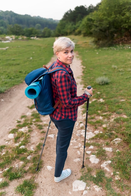 Donna anziana turistica con bastoncini da trekking