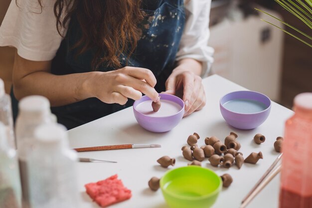 Donna artigiana che produce ceramiche in miniatura