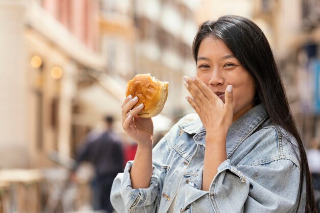 Donna asiatica che è felice dopo aver acquistato cibo di strada