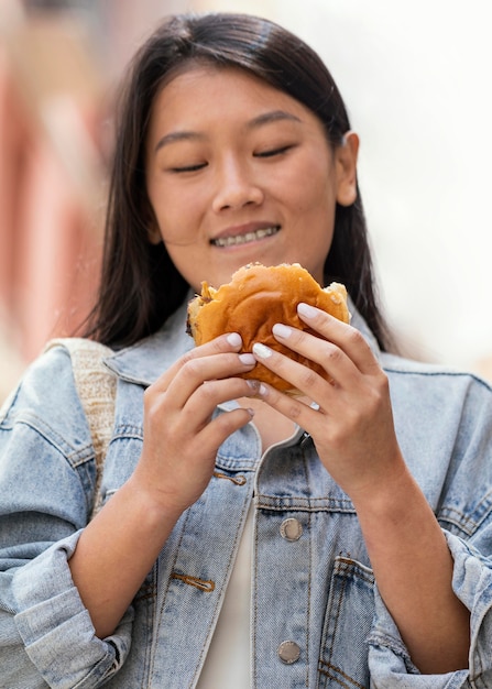 Donna asiatica che è felice dopo aver acquistato cibo di strada