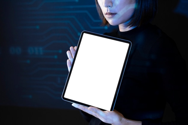Donna asiatica che mostra la tecnologia futura innovativa della compressa dello schermo in bianco