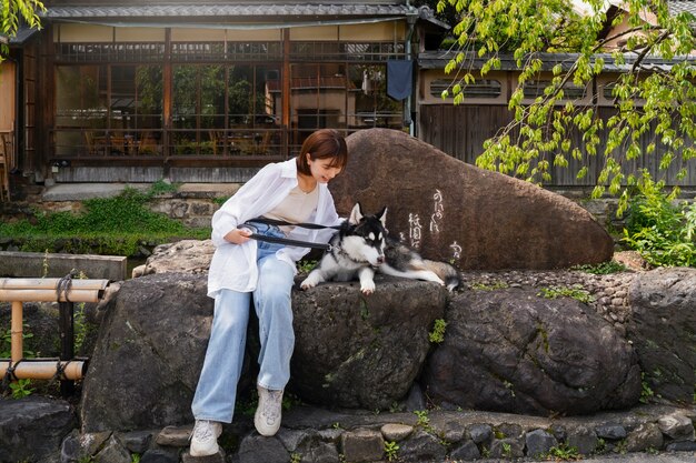 Donna asiatica che porta a spasso il suo cane husky all'aperto