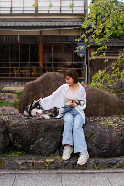 Donna asiatica che porta a spasso il suo cane husky all'aperto