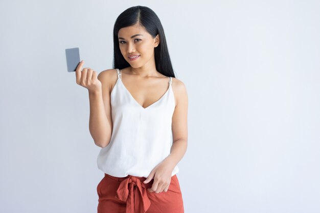 Donna asiatica soddisfatta che utilizza la carta di credito per il pagamento