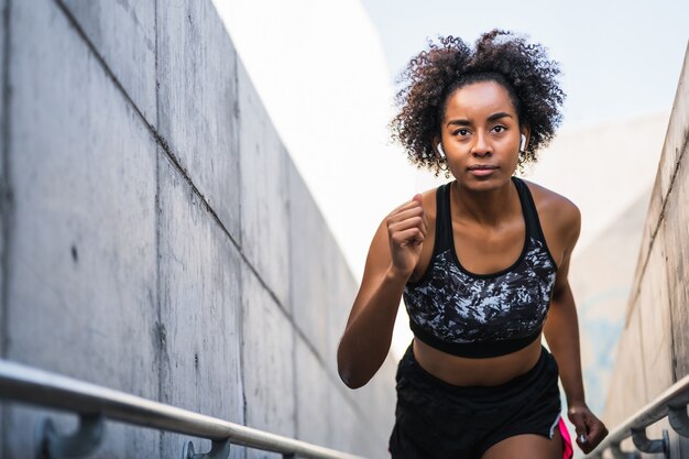 Donna atletica afro che corre e fa esercizio all'aperto