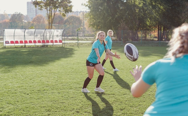 Donna atletica che passa un pallone da rugby